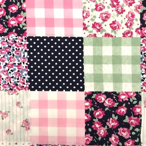 May include: A patchwork fabric with a variety of patterns, including pink and white gingham, black and white polka dots, and floral prints in shades of pink, blue, and white.
