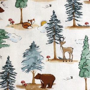 May include: A white fabric with a repeating pattern of brown bears, deer, foxes, and pine trees. The background is a light cream color with brown and green accents.