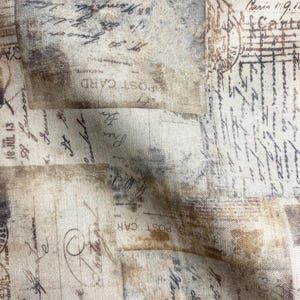 May include: A beige fabric with a vintage look featuring a repeating pattern of old, faded, and worn postage stamps with handwritten text. The text includes "POST CARD" and "Paris 1.9.1".