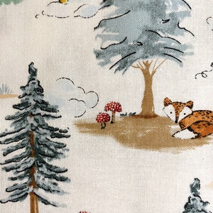 May include: A white fabric with a repeating pattern of a green pine tree, a blue tree, a yellow sun, white clouds, and a brown fox with red mushrooms.