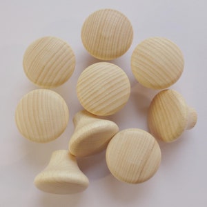 Könnte beinhalten: Ein Satz von neun Holzgriffen in hellbrauner Farbe. Die Griffe sind rund und haben eine glatte Oberfläche. Sie sind perfekt, um jedem Einrichtungsprojekt einen Hauch von rustikalem Charme zu verleihen.