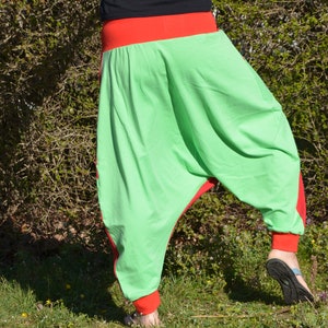 May include: Green and red harem pants with a wide leg and a loose fit. The pants are made of a soft, comfortable fabric.