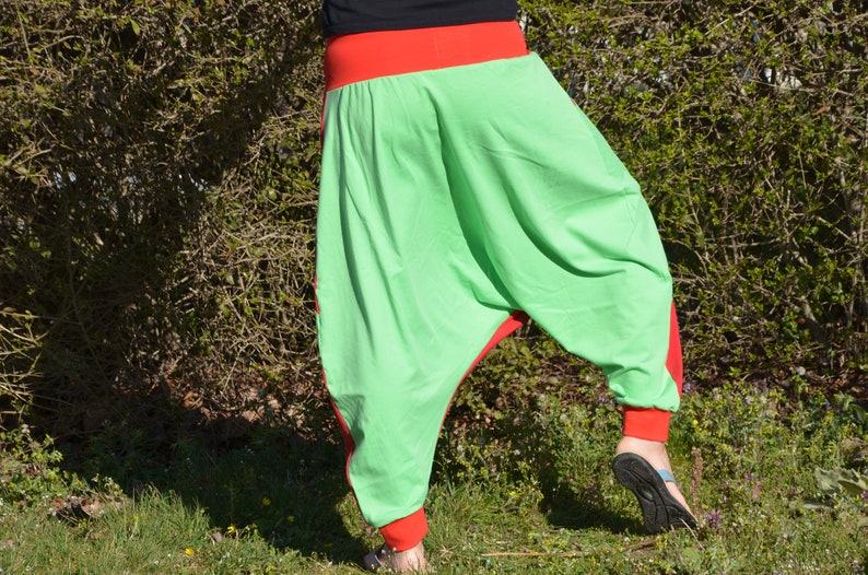 May include: Green and red harem pants with a wide leg and a loose fit. The pants are made of a soft, comfortable fabric.