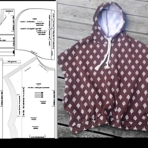 May include: A brown hooded poncho with a white leaf pattern. The poncho has a drawstring hood and short sleeves.