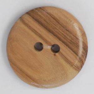 May include: Close-up of a large, round wooden button with two holes. The button has a light brown color with darker brown wood grain patterns. The button is approximately 1.5 inches in diameter.