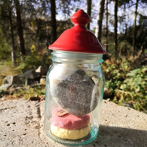Vintage glass storage jar with red porcelain lid