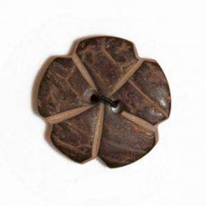 Puede incluir: Un botón marrón único y grande con un diseño en forma de flor. El botón está hecho de madera y presenta cinco pétalos con un agujero central para coser. Los pétalos están separados por segmentos de madera de color más claro, creando un efecto de contraste. El botón está sobre un fondo blanco.
