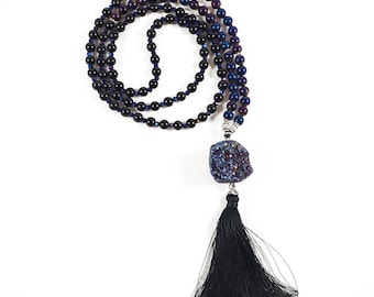 May include: A black beaded necklace with a blue and purple crystal pendant and a black tassel.