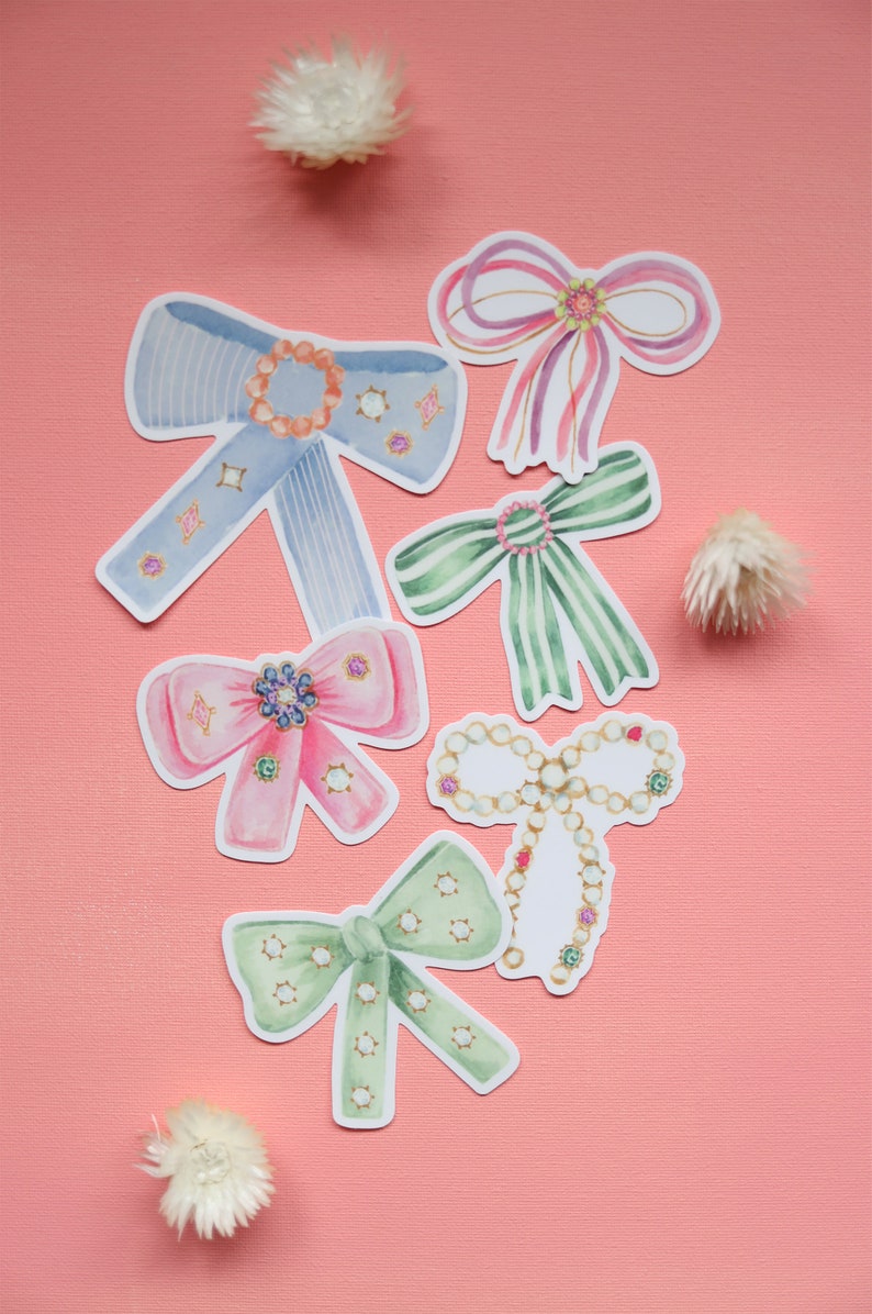 May include: Six watercolor illustrations of bows with various colors and patterns, including blue, green, pink, and white. The bows are decorated with jewels and pearls.