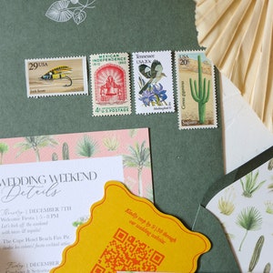 May include: A wedding invitation suite with a green envelope, a pink and green patterned card, and a yellow card with a QR code. The text on the card reads "Wedding Weekend Details" and includes dates and times for the wedding events. The envelope has stamps with images of a fish, a bell, a bird, and a cactus.