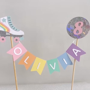 May include: A cake topper featuring a rainbow roller skate, a disco ball with the number 8, and a banner reading "Olivia".