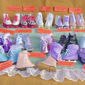 Op de afbeelding: Een verzameling rolschaatsen en ijsschaatsen in verschillende kleuren, waaronder wit, roze, zwart, paars en lichtblauw. Sommige schaatsen hebben witte veters en bontafwerking. Er is ook een lila draagtas.