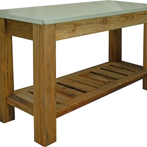 May include: A rustic wooden table with a galvanized metal top and a lower shelf. The table has a distressed wood finish and is perfect for a farmhouse or industrial style decor.