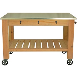 May include: A wooden kitchen island with a metal top and a bottom shelf. The island has wheels and three hooks on the front.