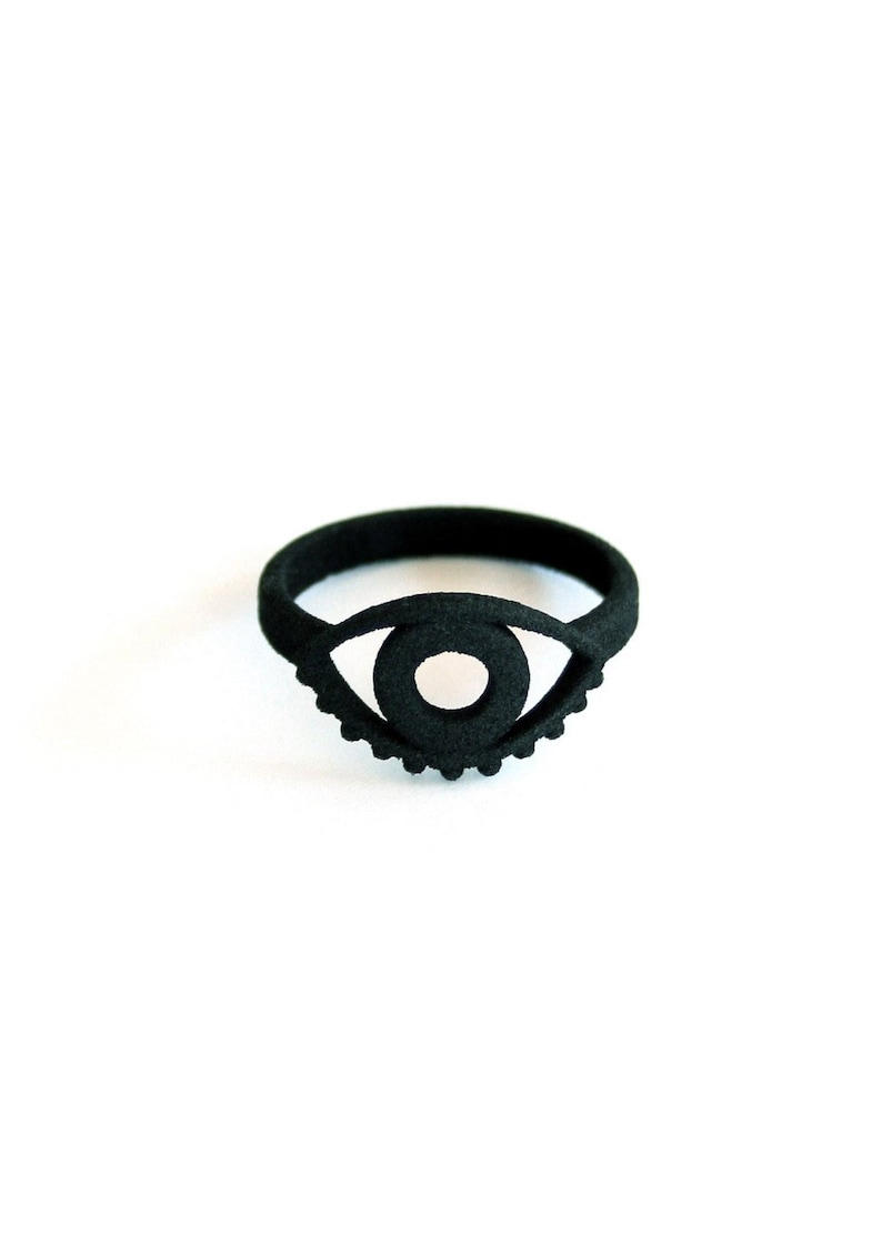 Bold graphic 3d printed black goth ring with evil eye design, displayed on white background