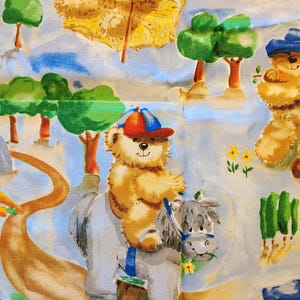 May include: Fabric with a repeating pattern of teddy bears in various scenes. Some bears wear hats and ride horses, while others are in a field with trees and hay. The color palette includes light blue, brown, green, and yellow.