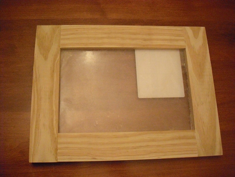 May include: A wooden picture frame with a clear glass insert and a white mat. The frame has a natural wood finish and is ready to display a photo or artwork.