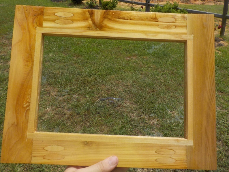 May include: A wooden picture frame with a clear glass insert. The frame is made of light wood with a natural finish. The frame is approximately 12 inches by 16 inches.