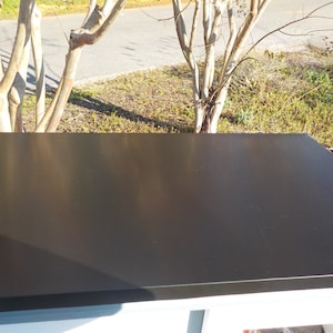May include: A black flat roof with a slight sheen. The roof is made of a durable material and is designed to withstand the elements.