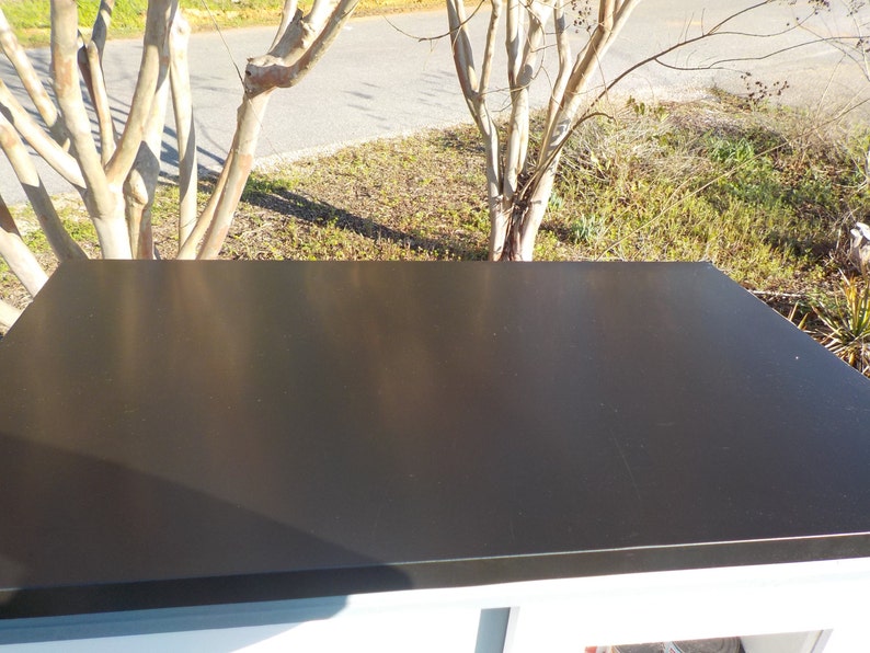May include: A black flat roof with a slight sheen. The roof is made of a durable material and is designed to withstand the elements.