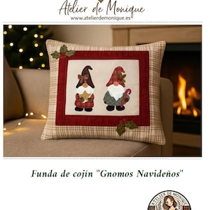 Könnte beinhalten: Ein Kissenbezug mit Karomuster und einem zentralen Feld mit zwei Zwergen in festlicher Kleidung. Die Zwerge tragen Hüte und halten Urlaubsgegenstände. Der Bezug hat einen roten Rand und ist mit "Funda de cojín "Gnomos Navideños" beschriftet.