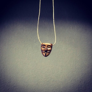 V.    A Guy Fawkes pendant.
