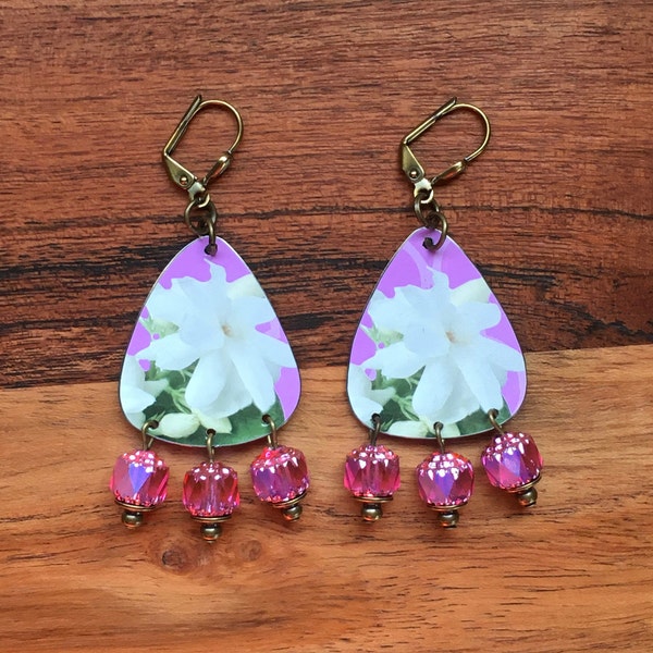 Fleur de jasmin blanc et feuillage vert sur fond rose avec un trio de boucles d’oreilles en boîte de thé recyclées AB Hot Pink Cathedral Bead