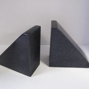 Puede incluir: Dos sujetalibros de granito gris oscuro, cada uno con forma de tri&aacute;ngulo rect&aacute;ngulo. Los sujetalibros tienen un acabado pulido y est&aacute;n dise&ntilde;ados para mantener los libros en posici&oacute;n vertical. Un art&iacute;culo decorativo y funcional.