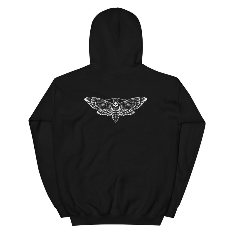 Puede incluir: Sudadera con capucha negra con un dise&ntilde;o blanco de una esfinge de la calavera en la espalda. Las alas de la polilla presentan patrones detallados. La sudadera tiene un cord&oacute;n y un bolsillo tipo canguro.