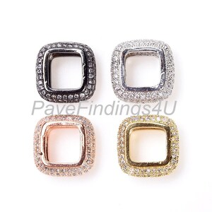 May include: Four square-shaped pendant charms with a clear crystal pave setting. The charms are in silver, gold, rose gold, and black.