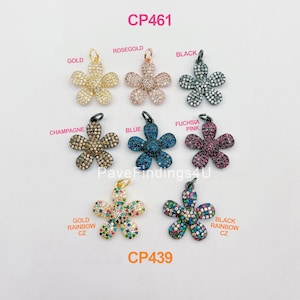 May include: Assortment of flower-shaped charms with pave CZ stones in various colors, including gold, rose gold, black, champagne, blue, fuchsia pink, gold rainbow, and black rainbow. The charms are labeled with their color and style, and the text "CP461" and "CP439" are also visible.