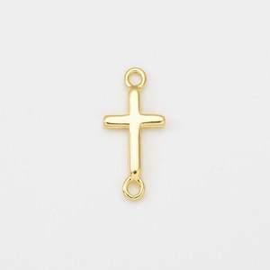 Op de afbeelding: Een kleine, goudkleurige kruisvormige hanger met een eenvoudig ontwerp. Het kruis heeft een klassieke vorm met afgeronde randen en een lus aan de boven- en onderkant om aan een ketting of andere sieradenonderdelen te bevestigen. De hanger wordt tegen een witte achtergrond getoond.