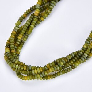 May include: A strand of green and yellow jade beads. The beads are round and have a smooth, polished finish.