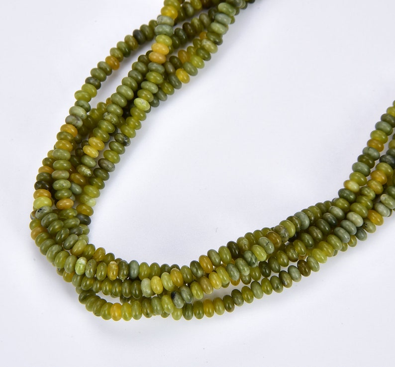 May include: A strand of green and yellow jade beads. The beads are round and have a smooth, polished finish.