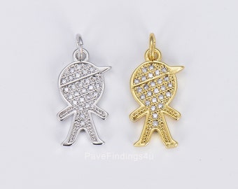 May include: Two charm pendants in the shape of a stick figure with a hat. The charm on the left is silver with clear cubic zirconia stones. The charm on the right is gold with clear cubic zirconia stones.