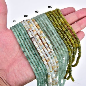 May include: A hand holding strands of green, blue, and white gemstone beads. The beads are arranged in rows, labeled 01 through 04.
