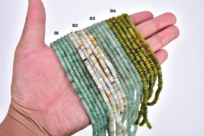 May include: A hand holding strands of green, blue, and white gemstone beads. The beads are arranged in rows, labeled 01 through 04.