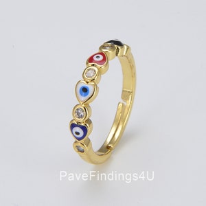 May include: Gold ring featuring a row of small hearts, each with an evil eye charm in blue, red, and black. The ring is adjustable.