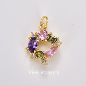 May include: Gold charm with a square frame of colorful gemstones. The charm features a purple, pink, and green oval-shaped stones with smaller clear stones around the frame.  PaveFindings4U is printed below the charm.
