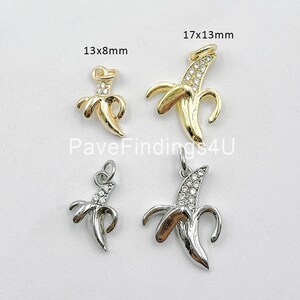 May include: Four gold and silver banana charms with clear rhinestones. The charms are in two sizes: 13x8mm and 17x13mm. PaveFindings4U is printed on the white background.