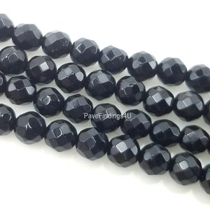 May include: Black faceted gemstone beads, approximately 8mm in size. The beads are strung together in a strand, showcasing their multifaceted design.