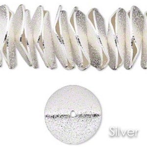 May include: Silver-toned metal beads with a textured surface. The beads are shaped like small, flat discs with a hole in the center. The beads are arranged in a row, and the word "Silver" is printed below the beads.