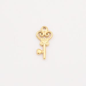 May include: A gold-toned key charm with a heart-shaped detail at the bottom and a decorative flower design on the keyhole.