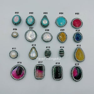 May include: A collection of various gemstone beads with silver-colored rhinestone borders. The beads feature a variety of colors, including pink, turquoise, yellow, and black. The image includes the text "PaveFindings4U".