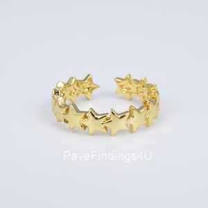 May include: A gold-toned adjustable ring with a band of small star-shaped charms.