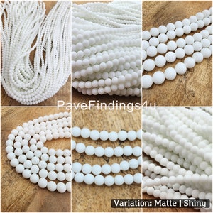 May include: White round beads in matte and shiny finishes. The beads are arranged in rows, showing the different finishes. Variation: Matte | Shiny