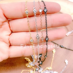 Puede incluir: Cuatro cadenas delicadas con pequeñas piedras de circonita cúbica transparentes. Las cadenas son de oro, plata, oro rosa y negro.