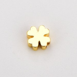 May include: A gold-coloured four-leaf clover charm.