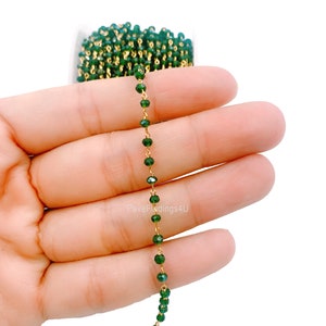 Puede incluir: Una hebra de cuentas de cristal verde enhebradas en una cadena de oro. Las cuentas son facetadas y tienen un acabado brillante. La cadena es delicada y tiene un calibre fino. La hebra mide aproximadamente 45 cm de largo.