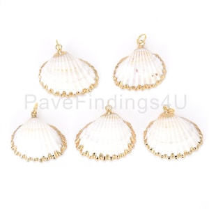 May include: Five white seashell pendants with gold-colored trim and a small loop at the top for jewelry making. The shells have a textured surface and are arranged on a white background. These pendants are ideal for creating beach-themed jewelry.